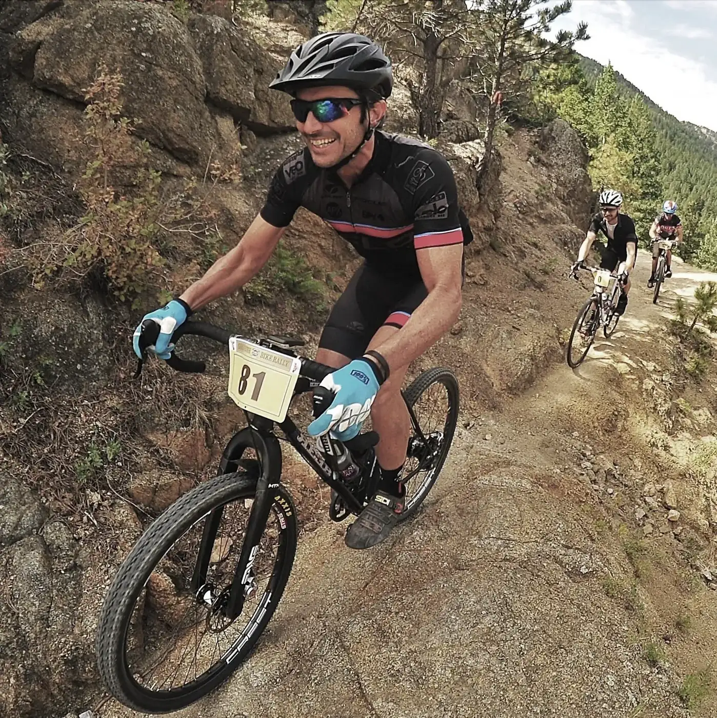 Rider descending a gravel road with hills behind