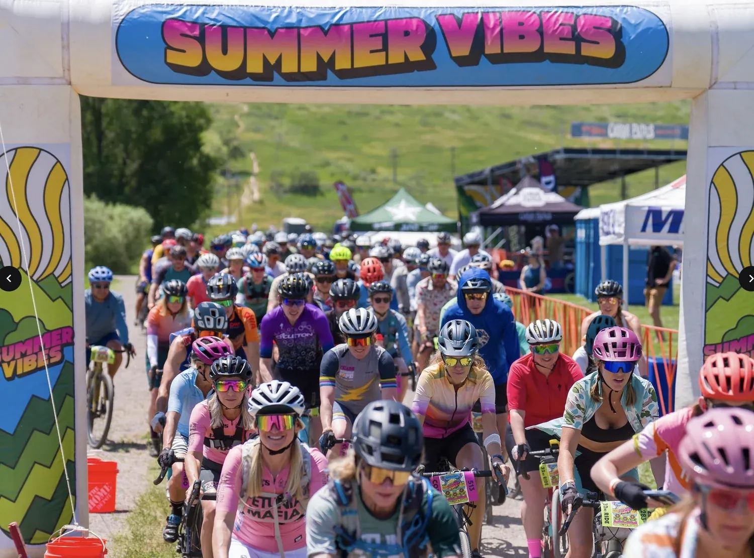 Hundreds of riders under the Summer Vibes start arch