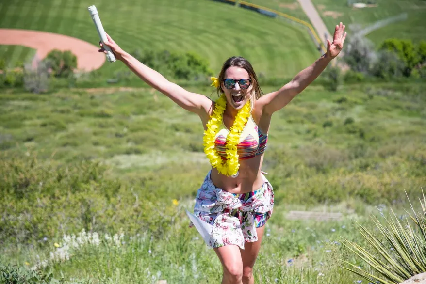 Runner celebrating with arms up on the hillside