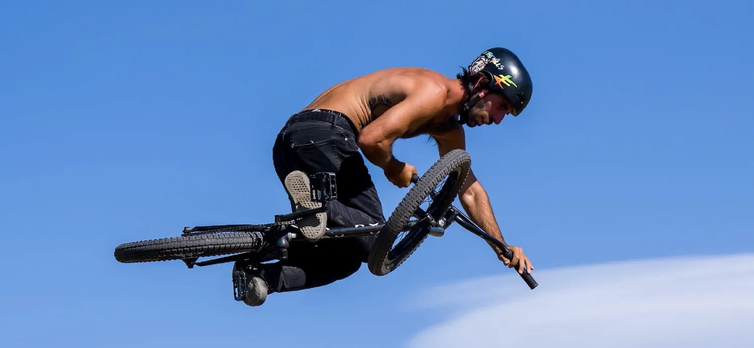 BMX rider mid air against a blue sky