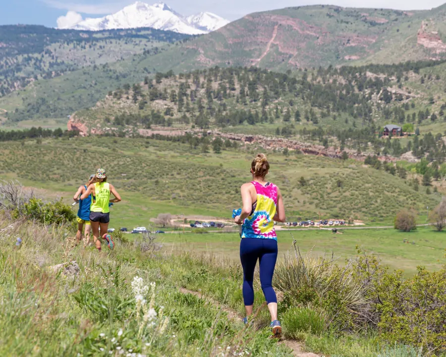 Runners on the ridge with Longs Peak in the distance