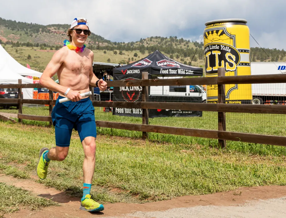 Runner passing the festival tents and giant Oskar Blues can