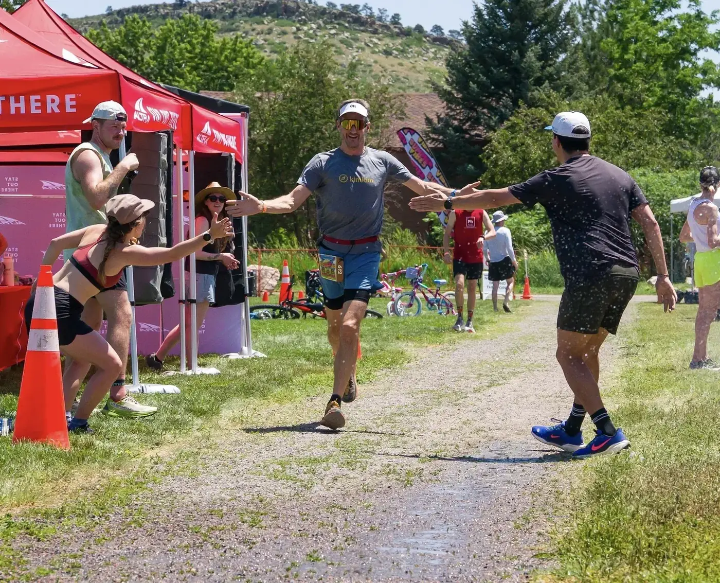 Aid station volunteers high fiving a runner