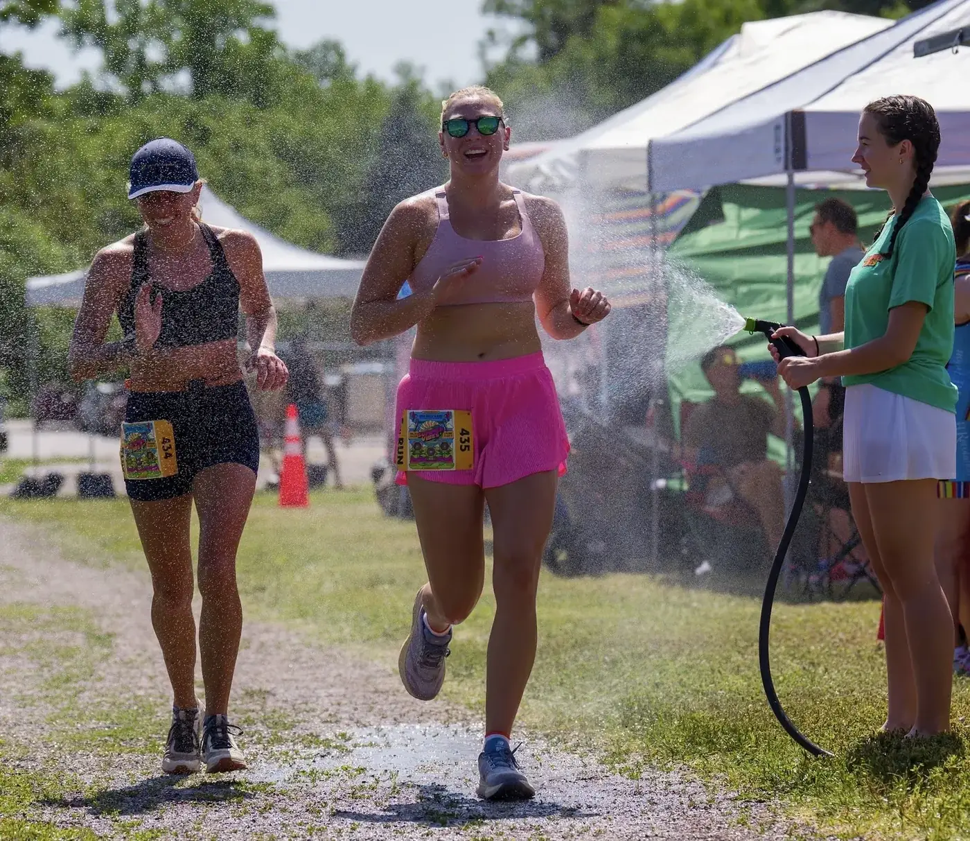 Runners cooling off under the water misters