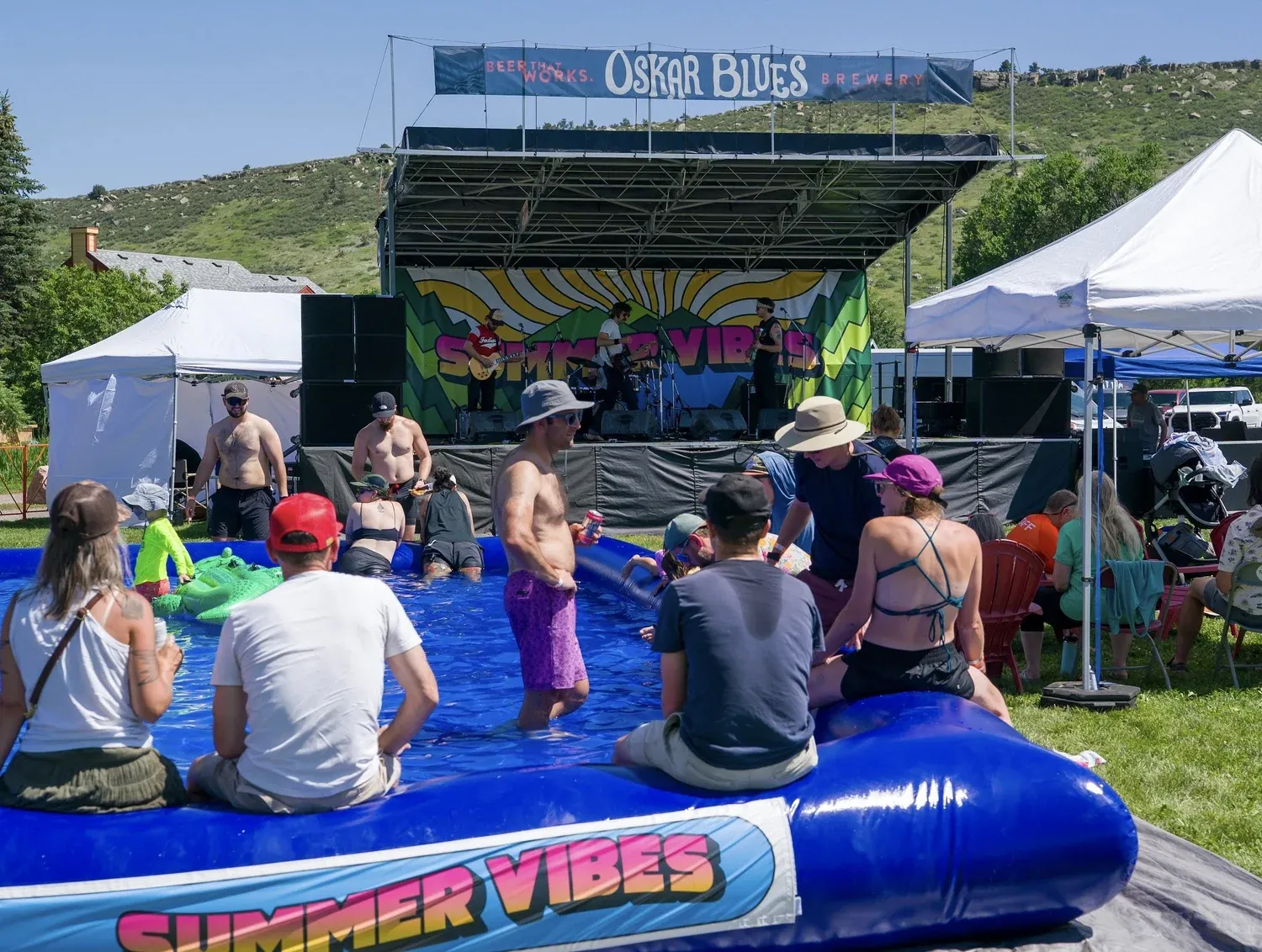 Crowd relaxing in the lounge pool by the stage